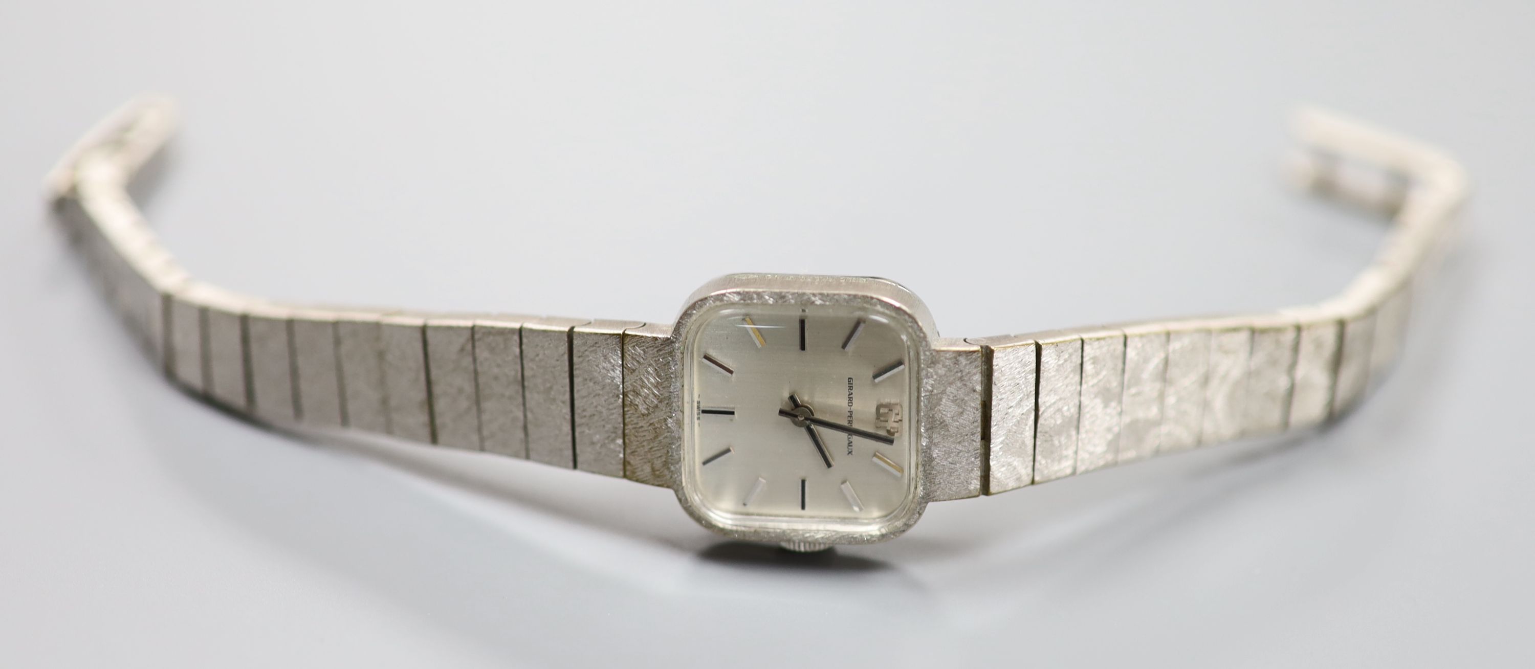 A ladys stainless steel Girard Perregaux manual wind wrist watch, on a textured white gold plated bracelet, overall 18.4cm,
